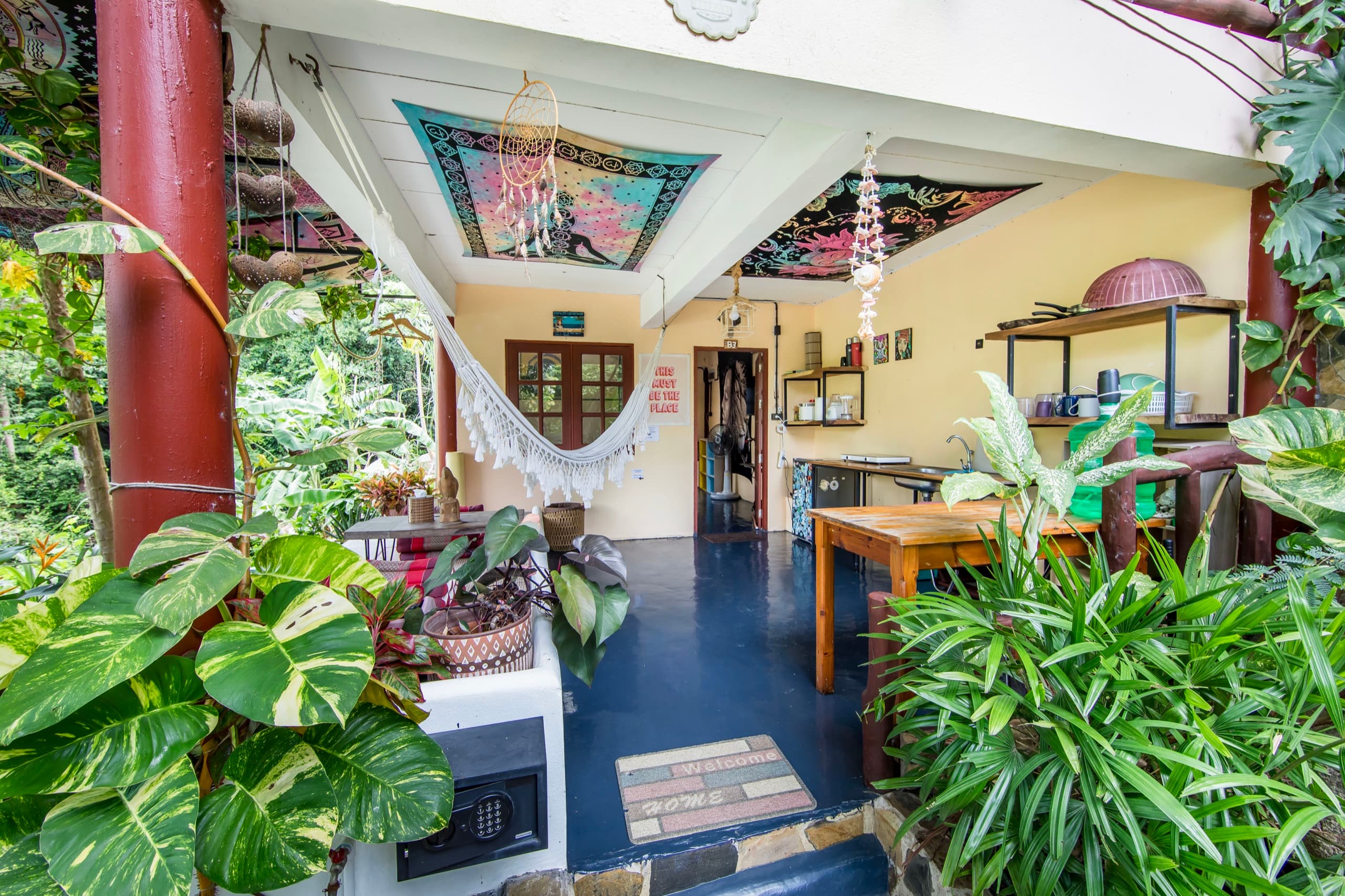 Slow Down entrance with hammock, red column, and batik ceiling
